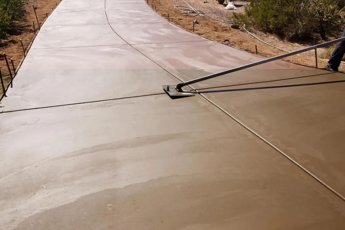 finisher pulling a bull float across a fresh concrete driveway pour in Royal Palm Beach