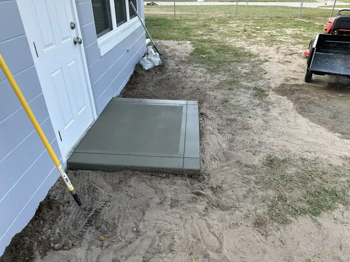 small new concrete pad poured at a side door of a house in Royal Palm Beach